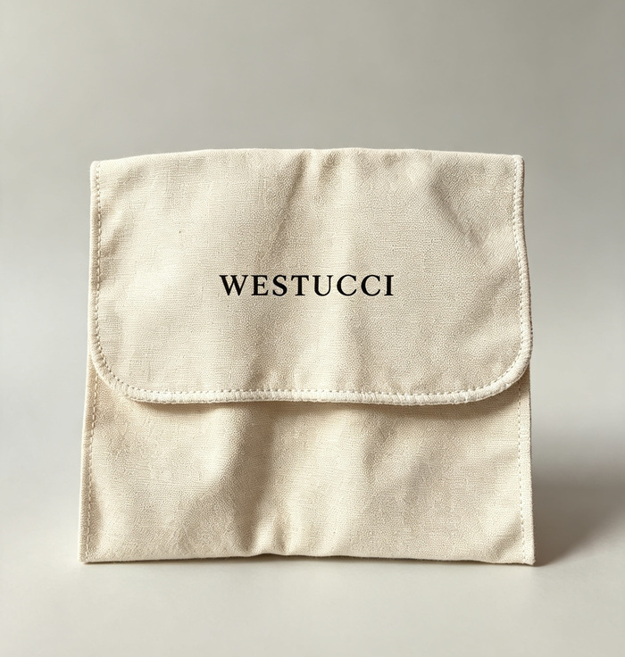The Westucci dust bag: a natural cotton pouch with a stitched flap and the Westucci name printed across it